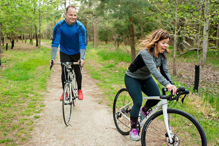 An athletic couple riding bikes for thier engagement session.
